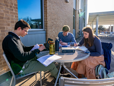Students on UDallas campus studying outdoors
